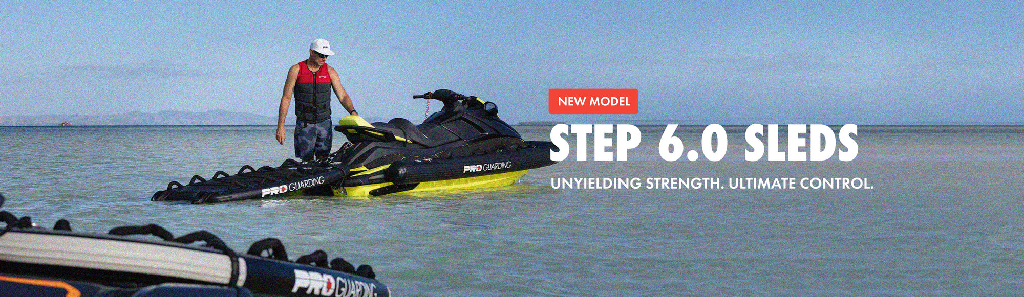 Person standing next to a Pro-Line watercraft on a beach with text about the 'Step 6.0 Sleds' model.